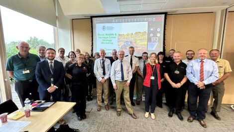 A group of people pose in front of a conference screen