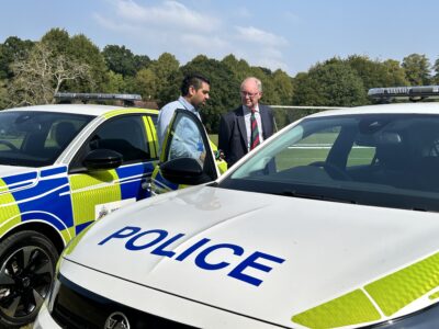 Two people look at a police car