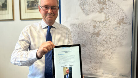 Philip Seccombe holds up a computer tablet showing an online survey