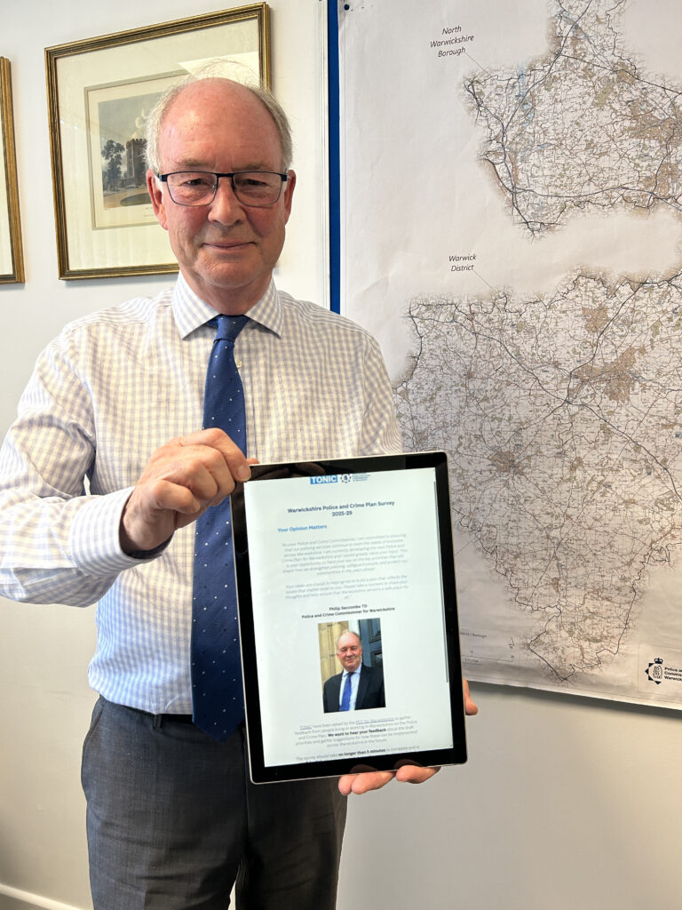 Philip Seccombe holds up a computer tablet showing an online survey