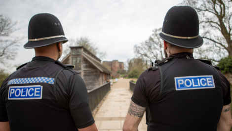 Uniformed officers walk down a street